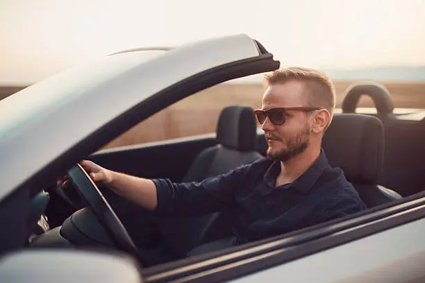 a guy driving a affordable luxury car