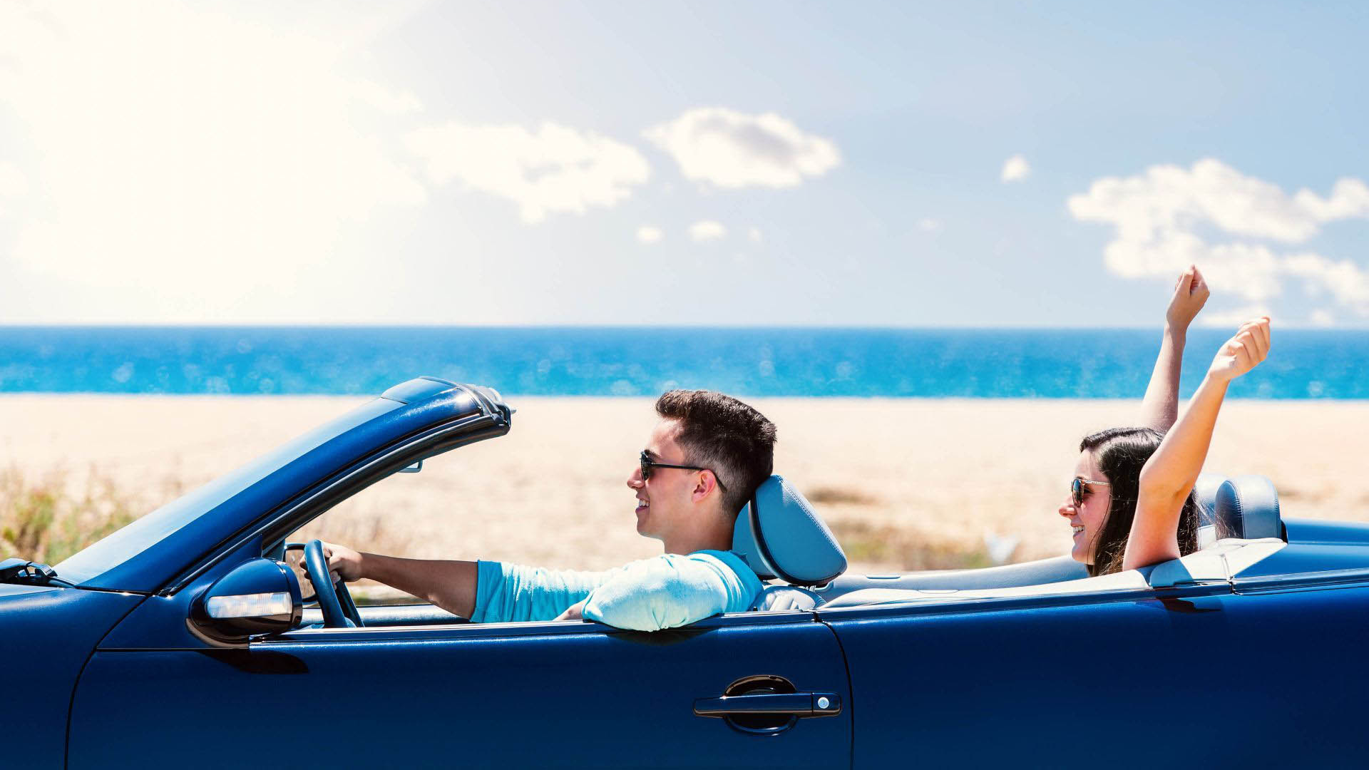 Couple enjoying in a convertible car rental