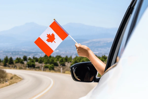woman holding canada flag open 600nw 2181618337 Memorial Day weekend means beach trips, backyard barbecues, and maybe a little escape with friends or family. But if you’re looking to rent a car for the long weekend, you’ll want to know: Are car rental places open on Memorial Day?