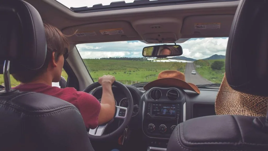 A guy driving in a long road trip