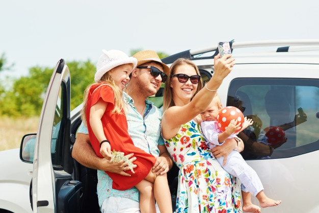 A family clicking photo after they rent a car